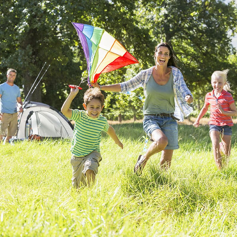 Familia volando cometas y divirtiéndose en un parque