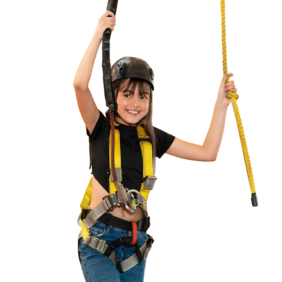 Niña con arnés disfrutando recorrido en alturas